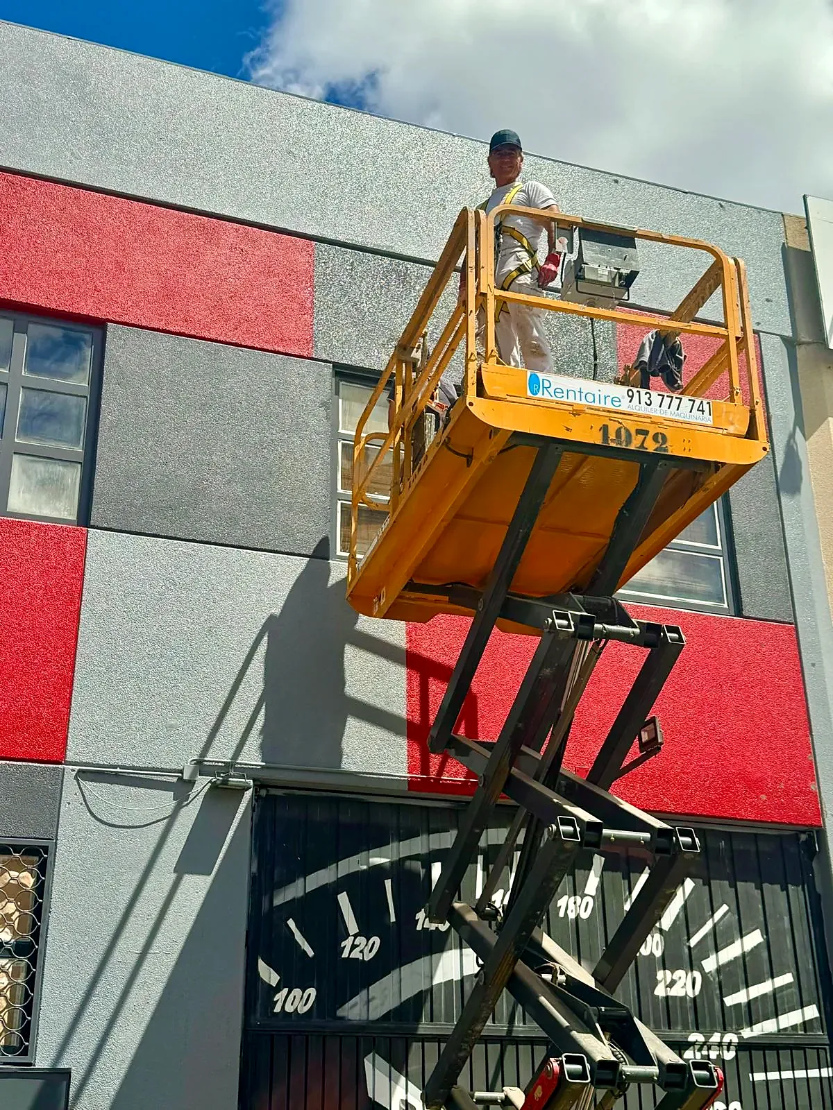 Pintando la fachada de una nave desde plataforma elevadora