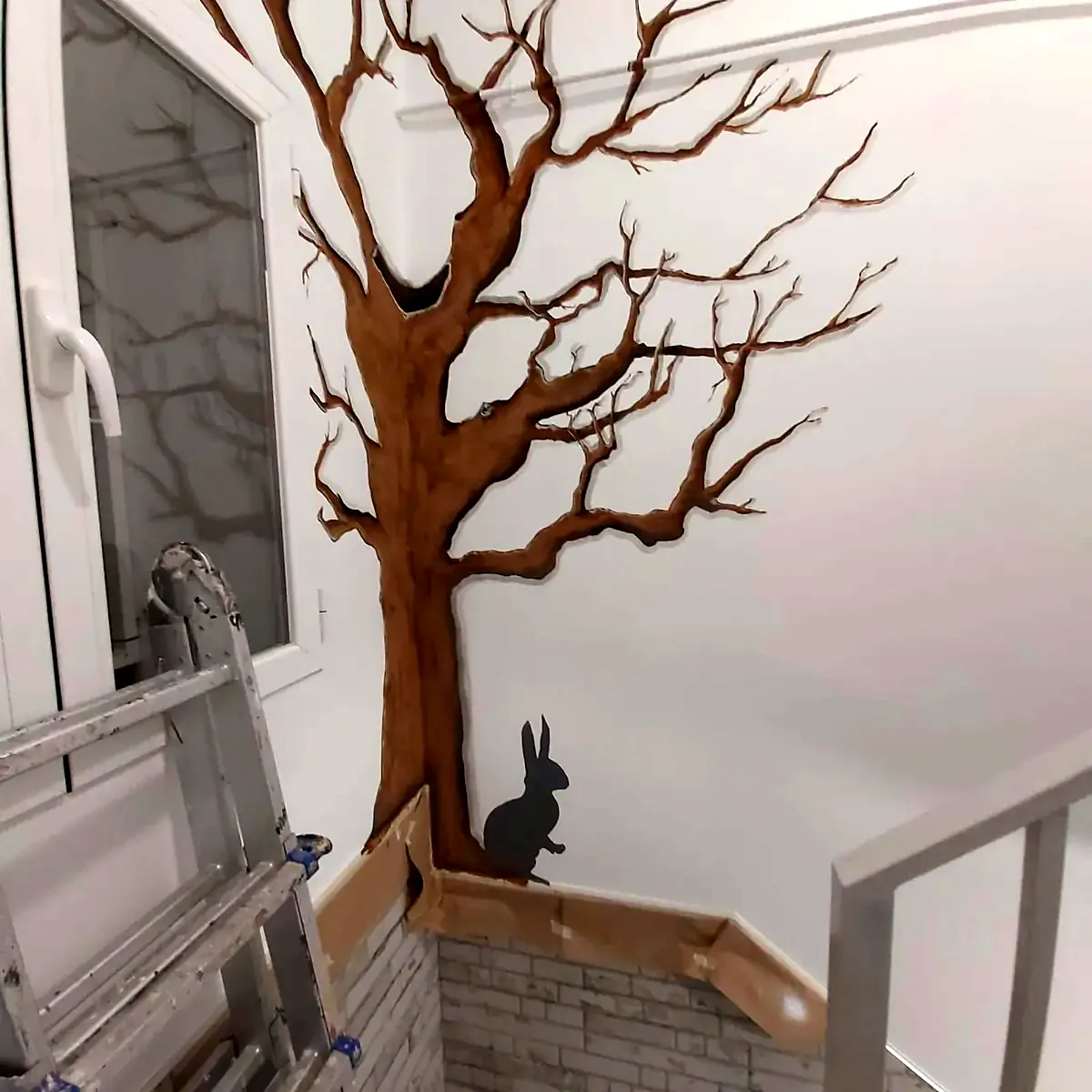 Mural de árbol pintado a mano en escalera